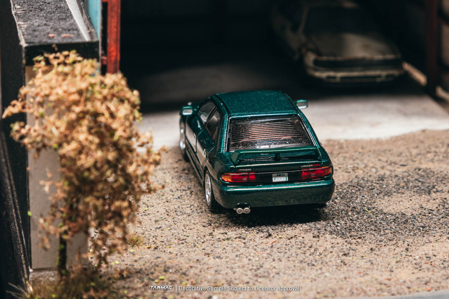 Small green model car on a textured surface with a blurred background