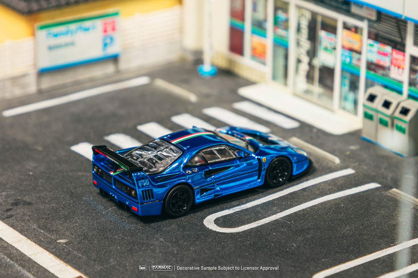 Blue toy car on a model road with a store in the background
