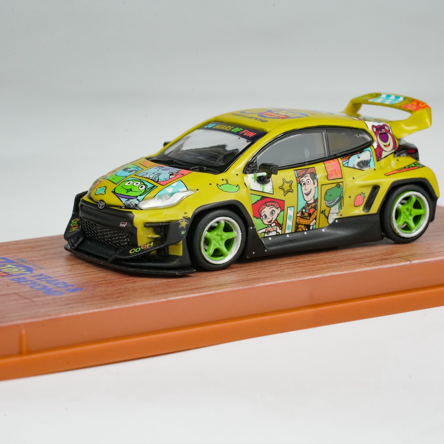 Colorful toy car with cartoon character design on a wooden platform