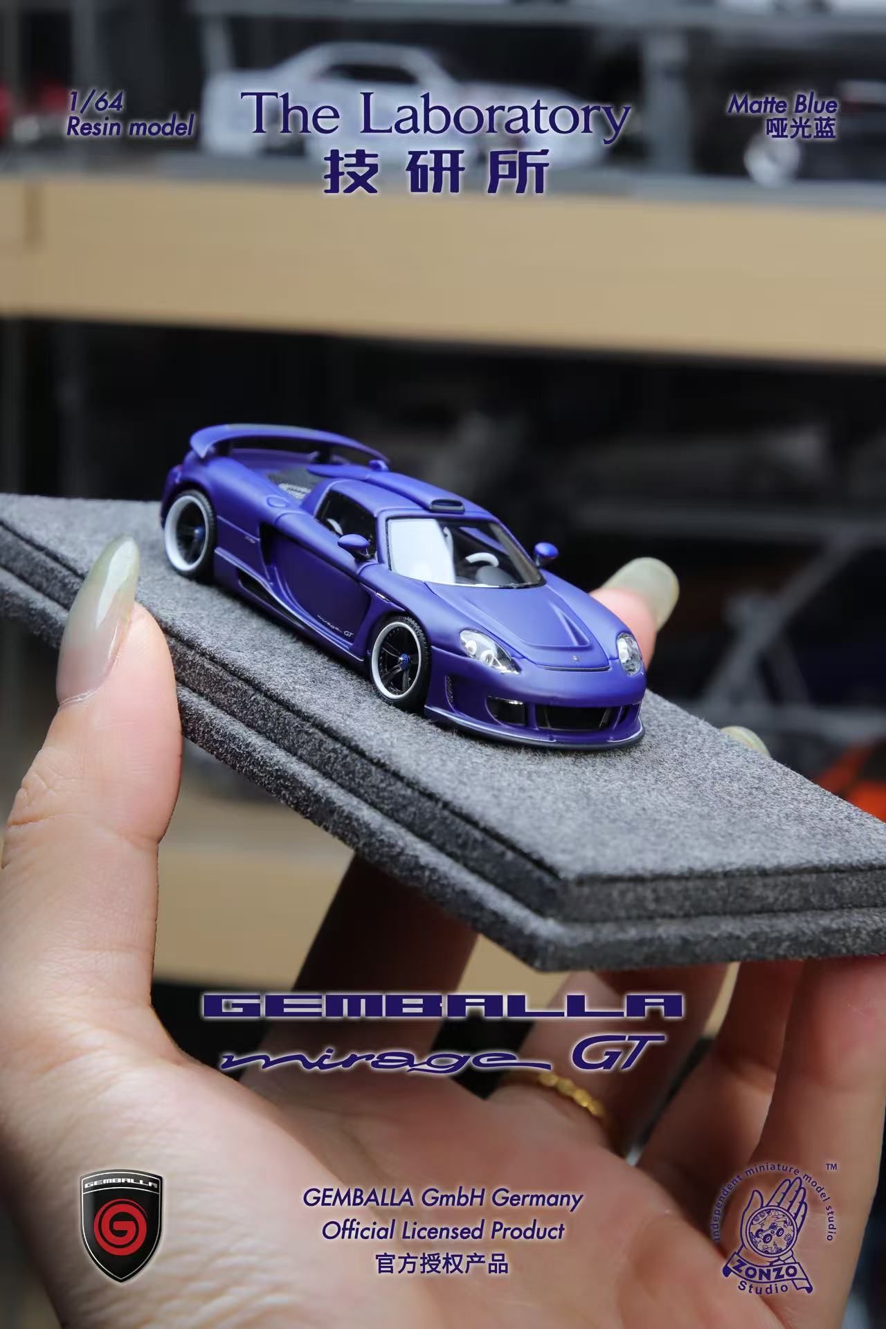 Model car of Gemballa Mirage GT held by a hand on a gray display stand.
