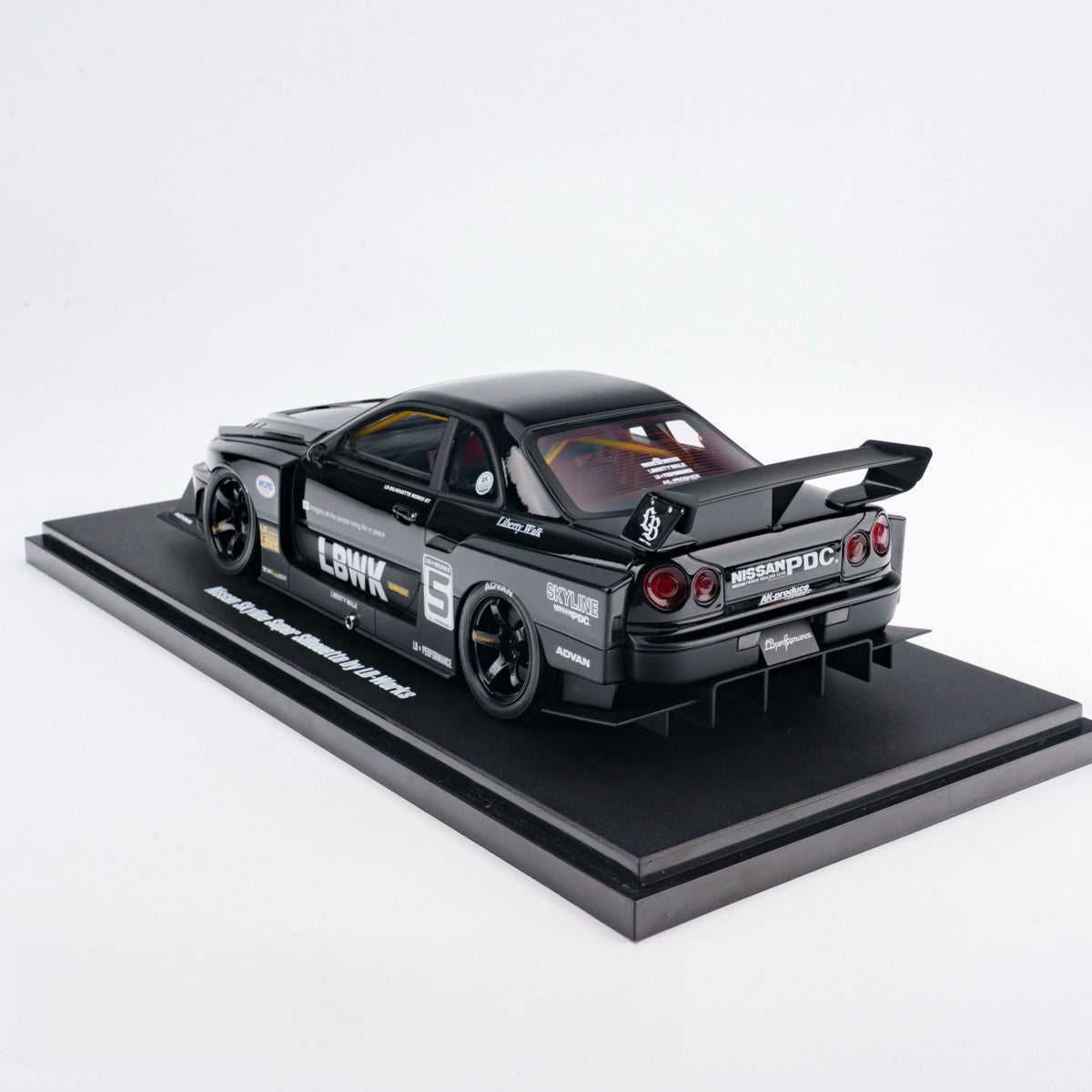 Model car on a black platform with a white background