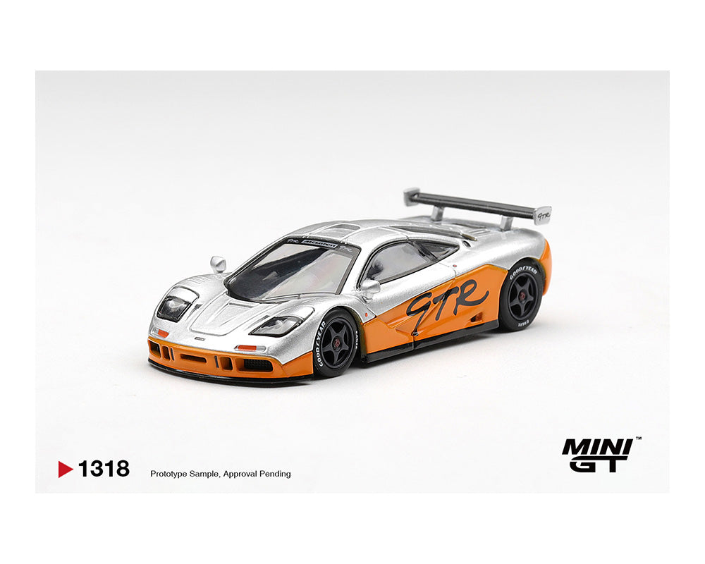 Model car with orange and silver design on a white background, featuring the Mini GT logo.