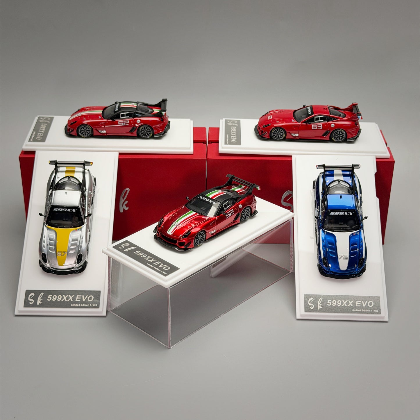 Collection of model cars on display with red, blue, and silver models.
