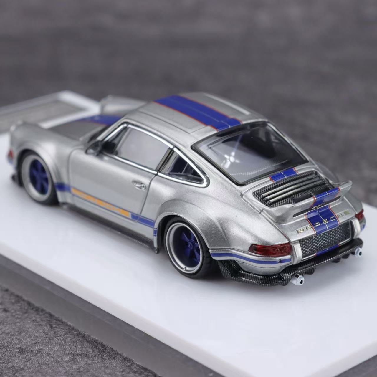 Model car with blue and orange stripes on a gray background