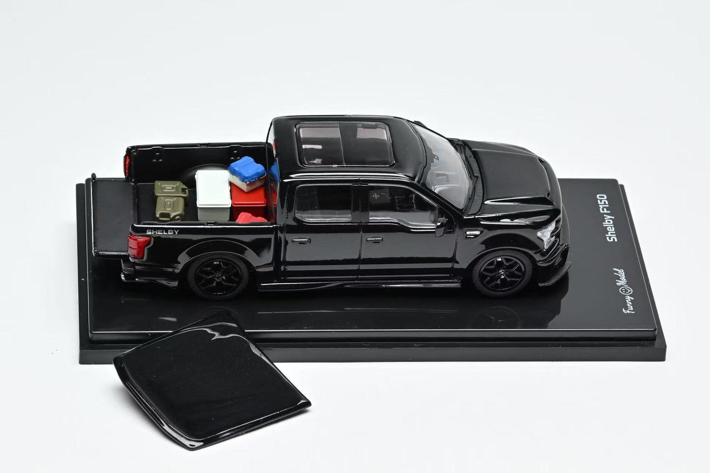 Black Ford Shelby F150 model truck with open bed on a gray background