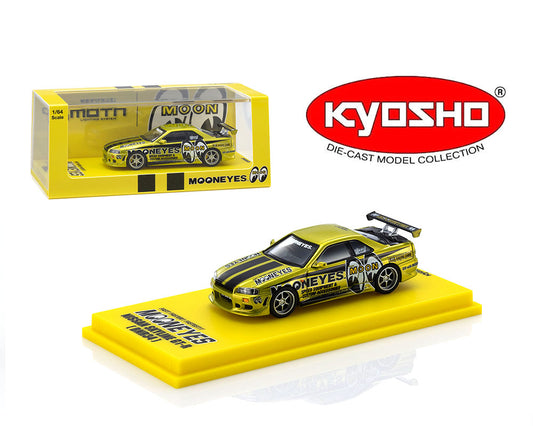 A Kyosho die-cast model car of the Mooneyes 'Moon' Toyota Corvette SSR, shown both inside its yellow retail packaging and displayed on a yellow base. The car features a metallic gold body with black stripes and racing decals.