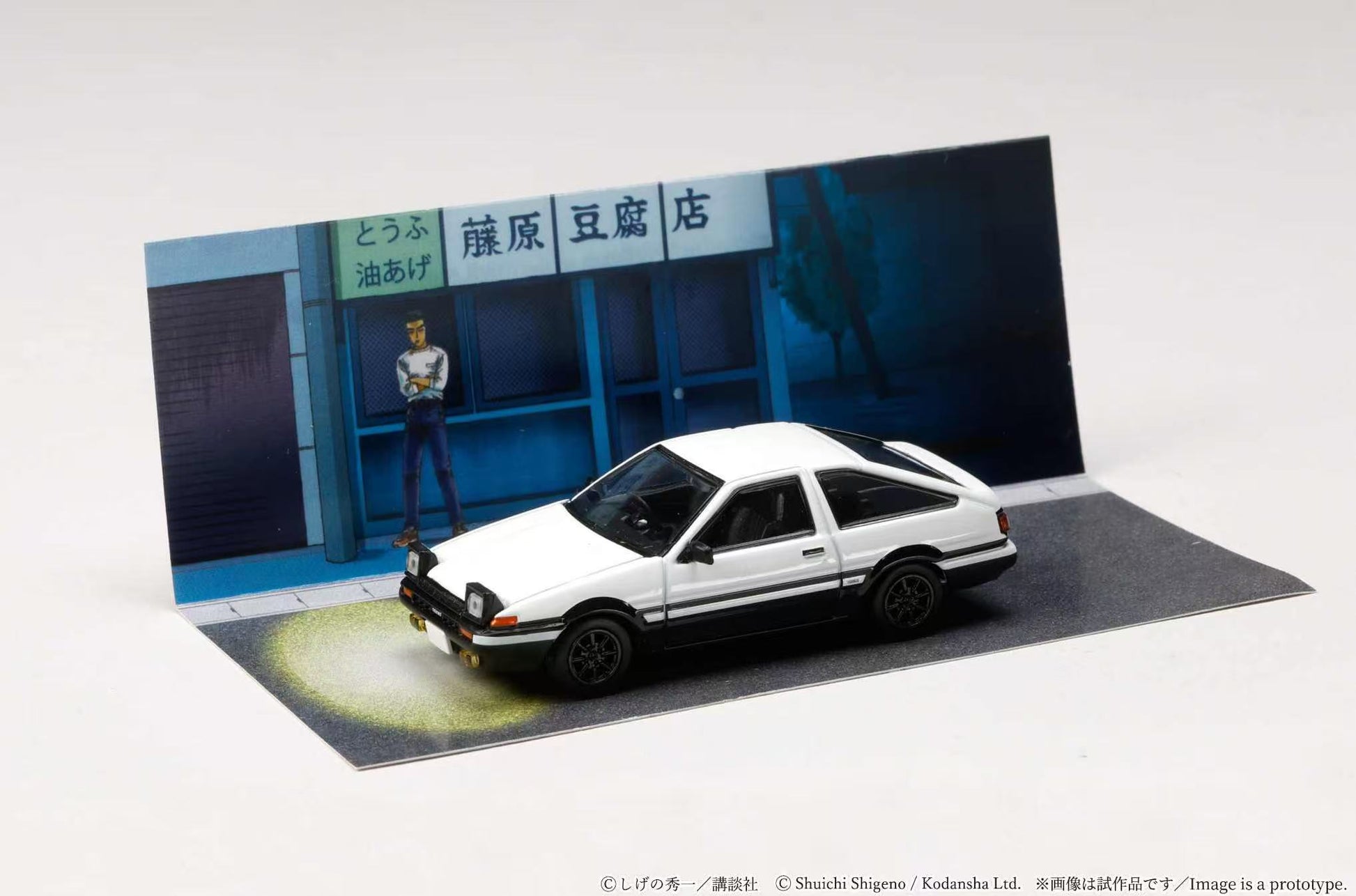Model car in front of a store with a person in the background
