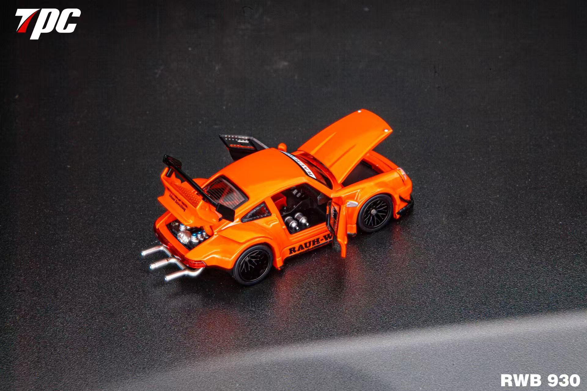 Orange model car with open doors on a dark surface, featuring the 7pc logo.