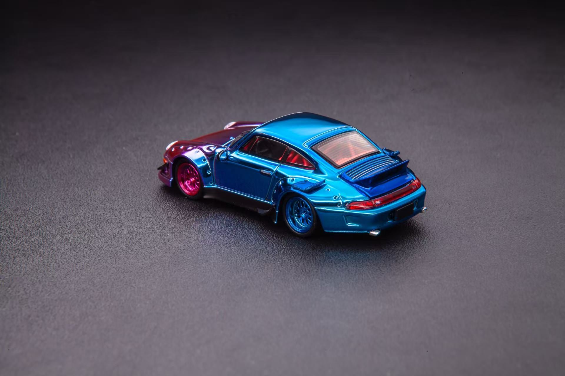 Blue toy car with red accents on a gray surface