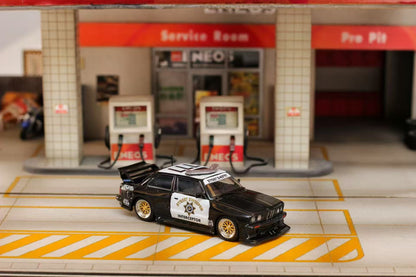Model car on a miniature gas station platform with 'NEO' branding.