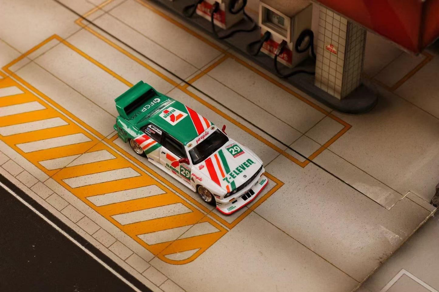 Model car on a scale model race track with a detailed background
