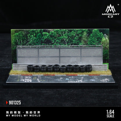 Model racing track with tires and fence, featuring MoreArt branding.