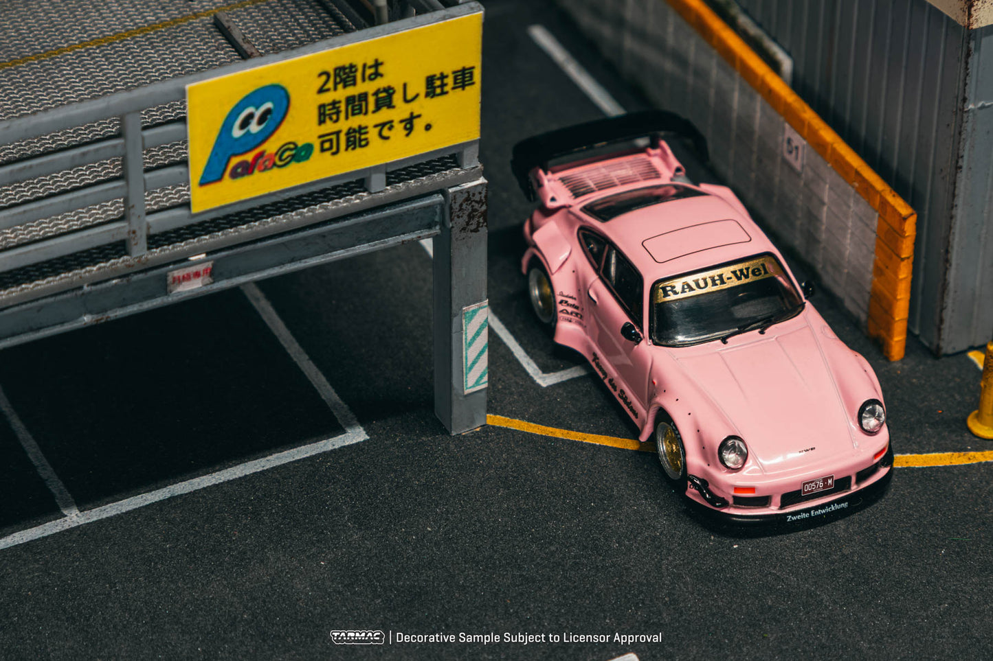 Pink sports car in a parking garage with a sign in the background