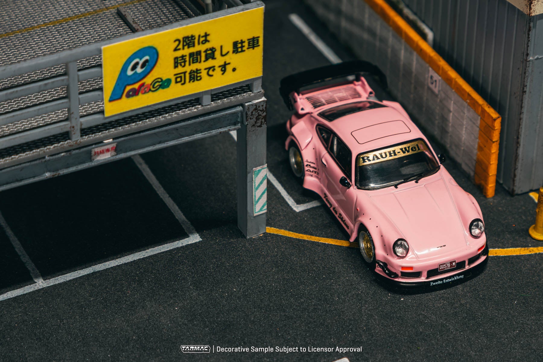 Pink sports car in a parking garage with a sign in the background