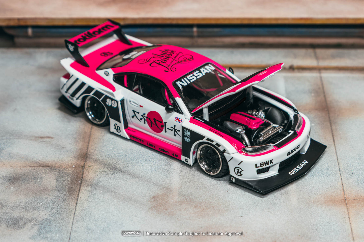 Model car with pink and black design on a wooden surface
