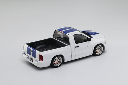 Model truck with a white body, black bed, and blue and red stripes on a gray background