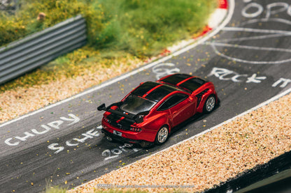 Red model car on a miniature race track with 'Opel' branding.