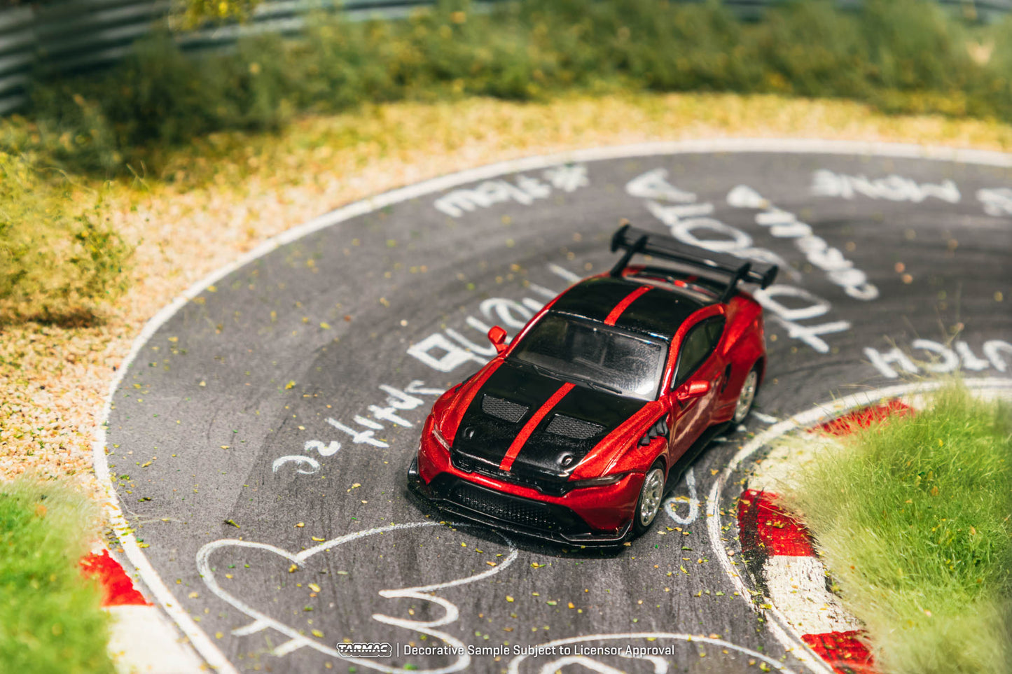 Red and black model car on a circular track with 'Nurburgring' branding.