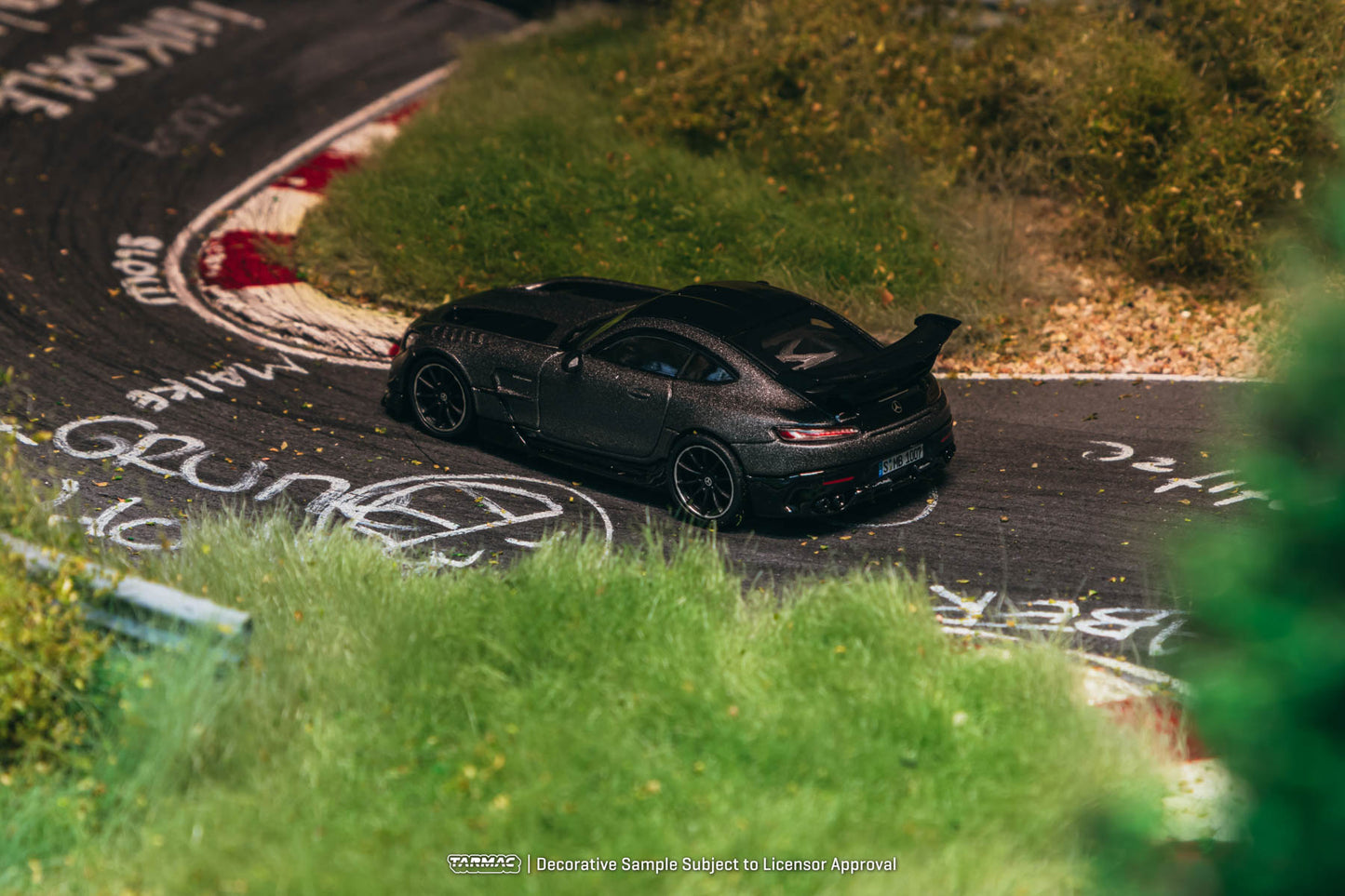Black sports car on a race track with 'Nürburgring' branding.