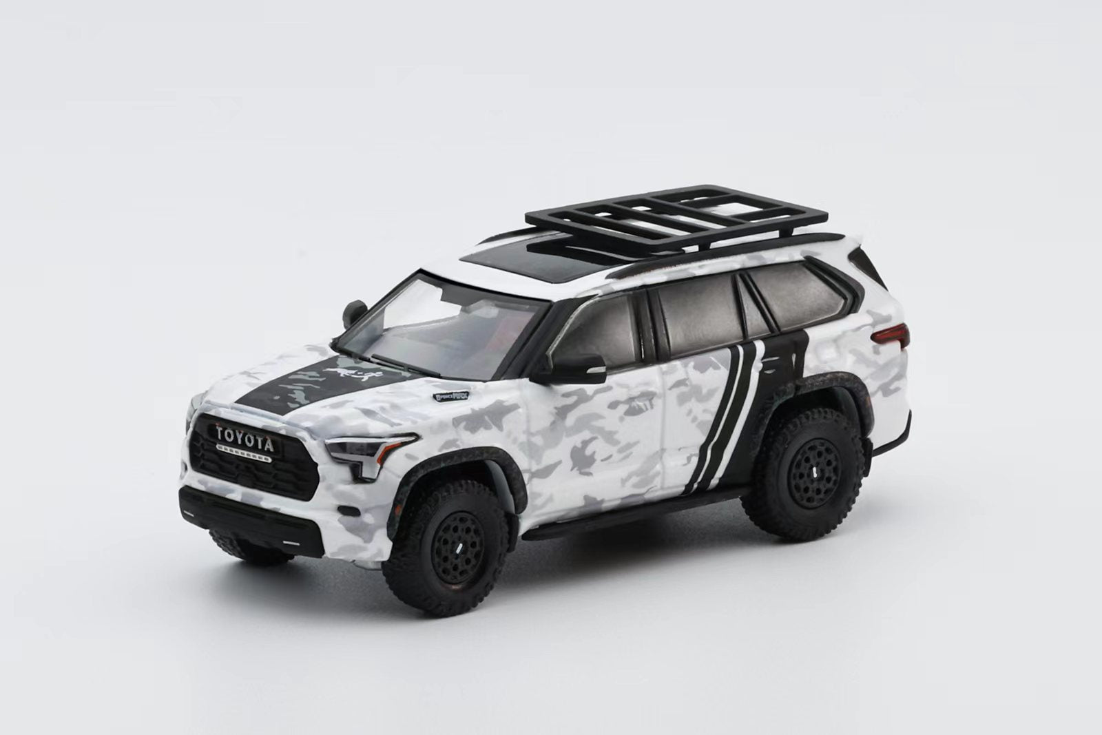 Model toy car of a Toyota SUV with camouflage pattern on a white background