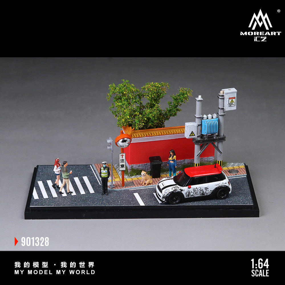 Model miniature of a street scene with a car, pedestrians, and buildings on a gray background.