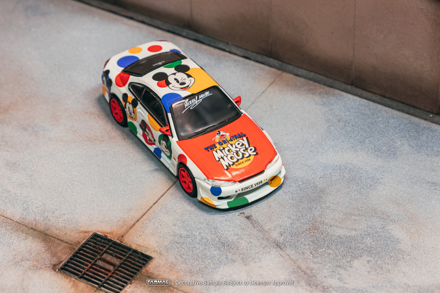 Colorful model car with Mickey Mouse design on a concrete surface