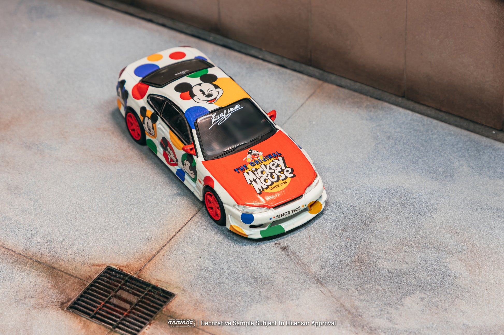 Colorful model car with Mickey Mouse design on a concrete surface