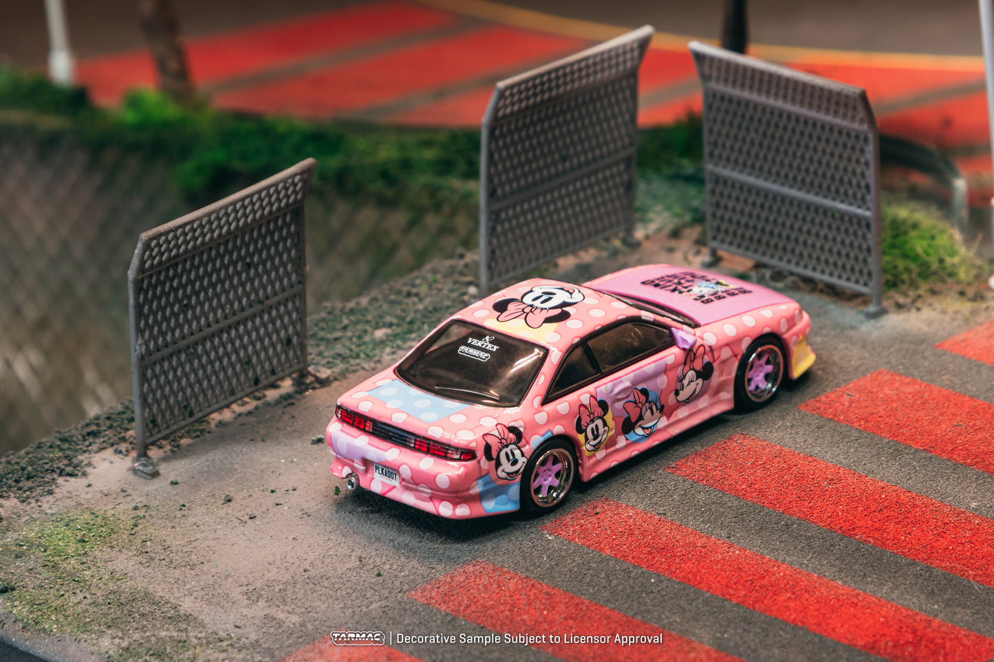 Pink toy car with cartoon design on a miniature race track