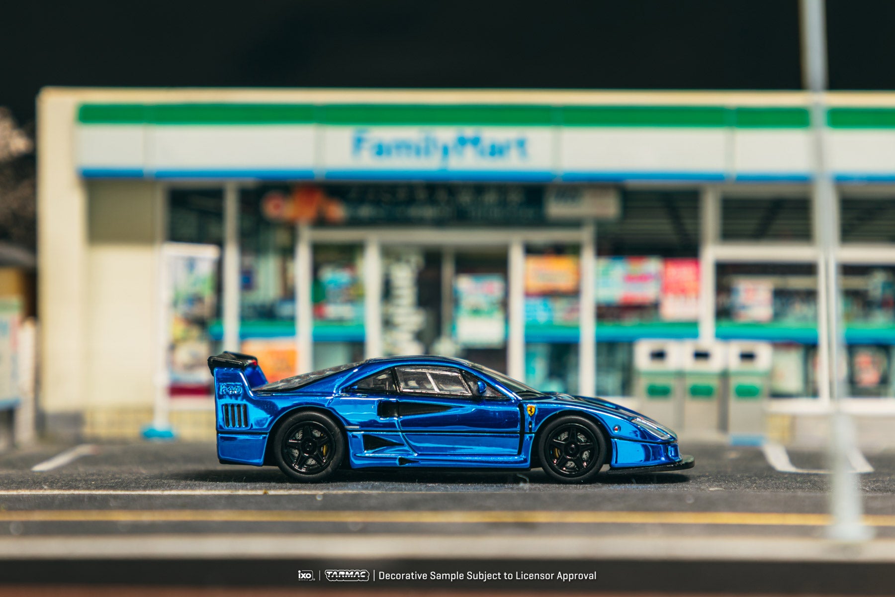 Blue sports car model on a road with a blurred store in the background