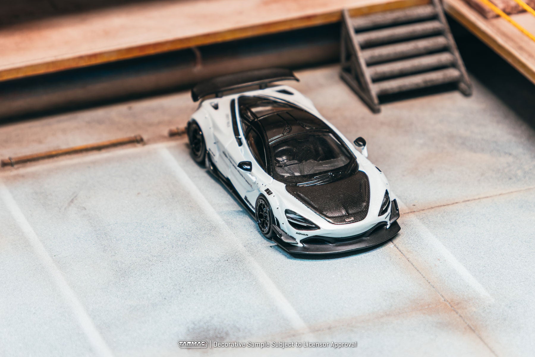 Model of a sports car on a textured surface with wooden background