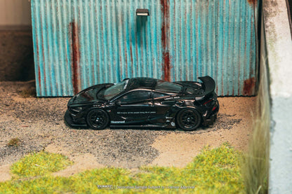 Black sports car model on a textured surface with a corrugated metal background