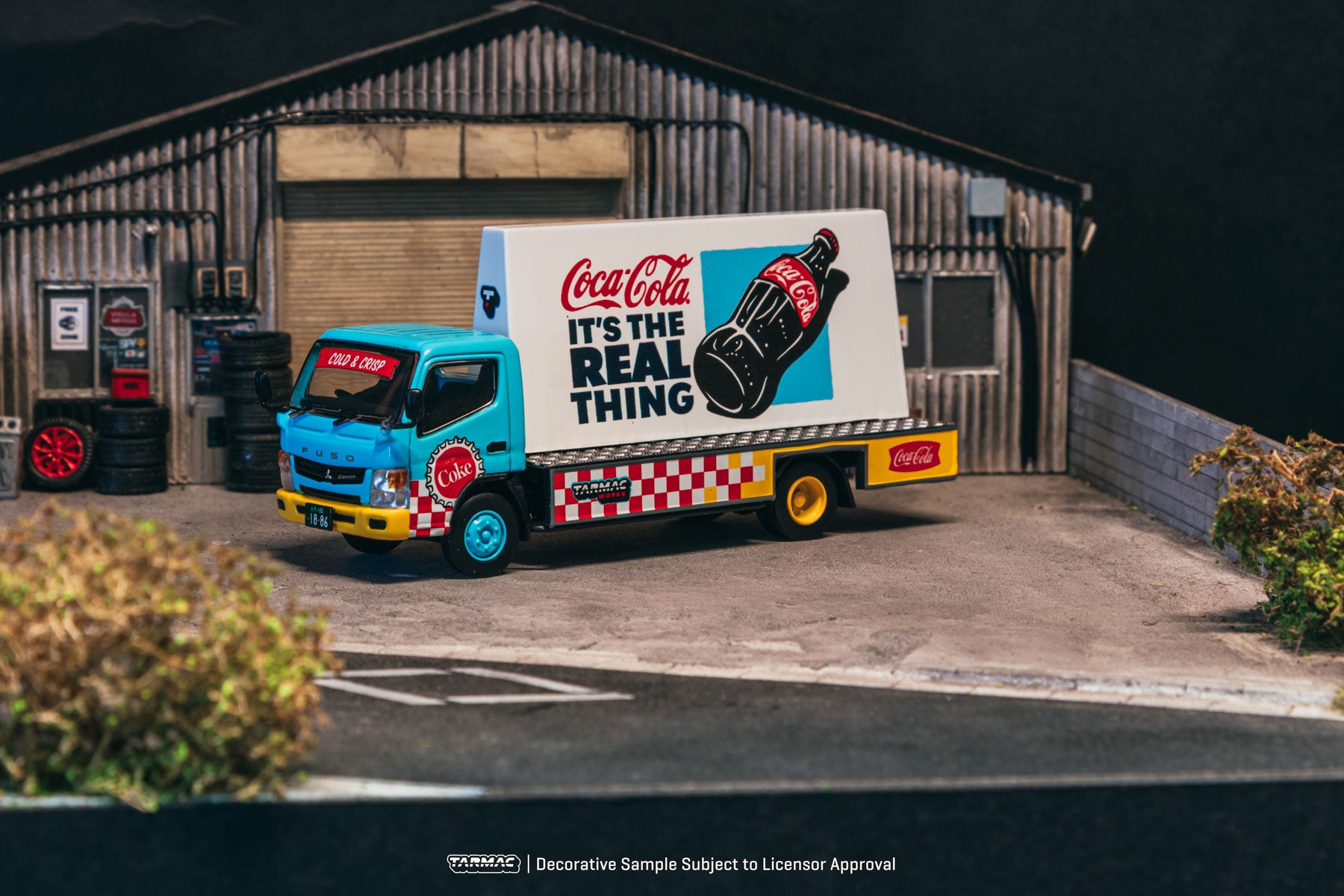 Model truck with Coca-Cola advertisement in front of a building