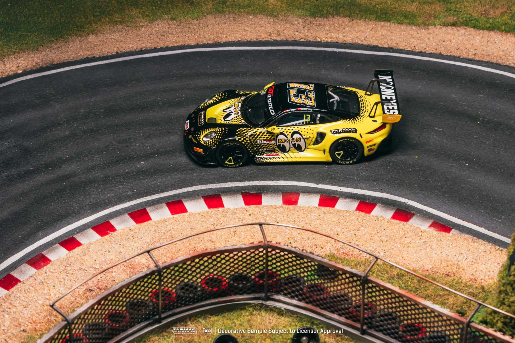 Yellow and black race car on a track with red and white curbs.