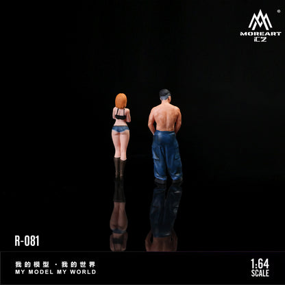 Two miniature figures of a man and a woman standing back-to-back on a reflective surface with 'MOREART' branding.