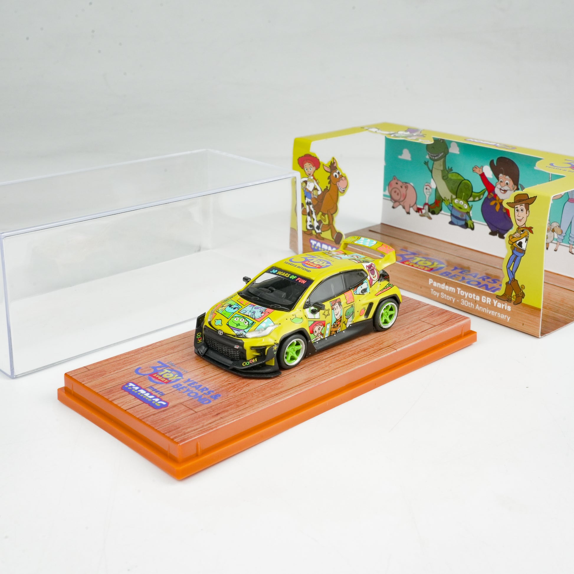 Toy car with colorful design on a display stand next to its packaging