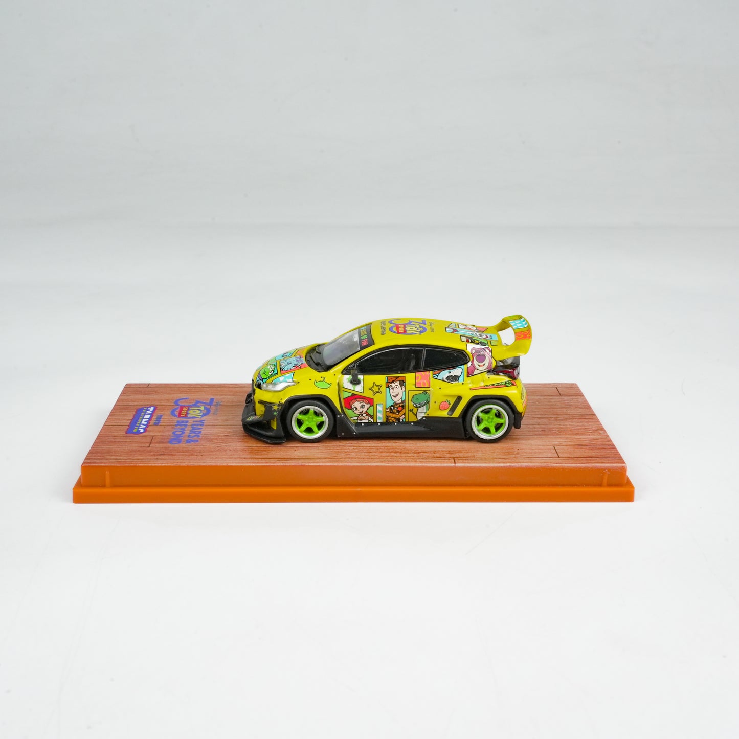 Colorful toy car on a display stand with a white background