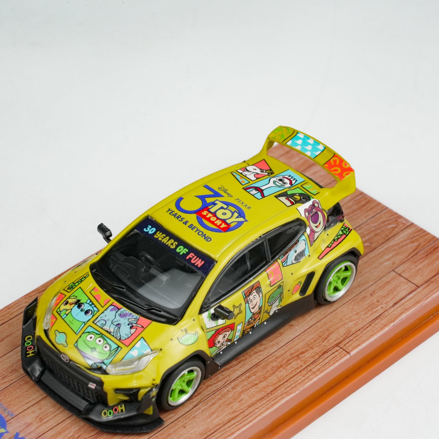 Colorful model car with cartoon graphics on a wooden display stand