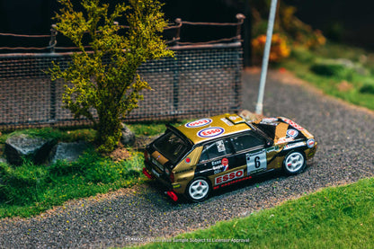 Model car on a miniature road with a tree and fence in the background
