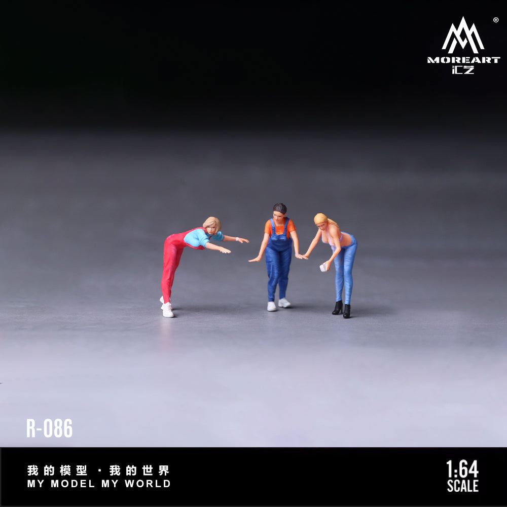 Three miniature figures interacting on a gray surface with 'MOREART' branding.