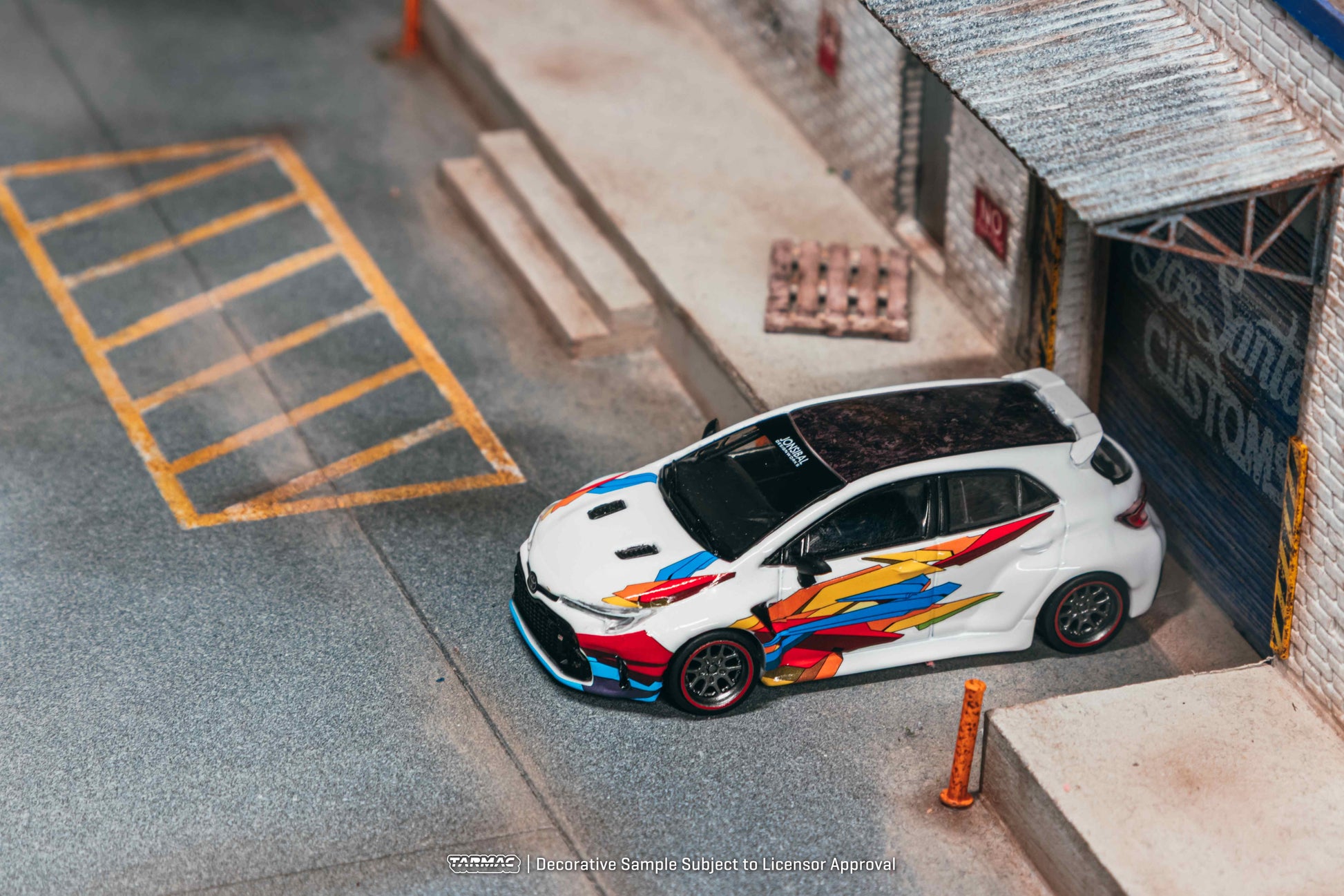 Model car with colorful design on a miniature parking lot and building setup