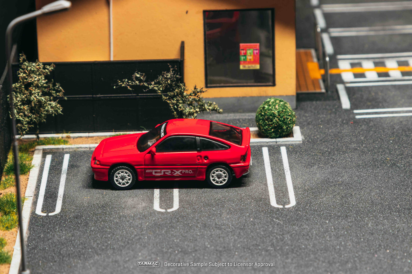 Red car parked in a parking space with a building in the background