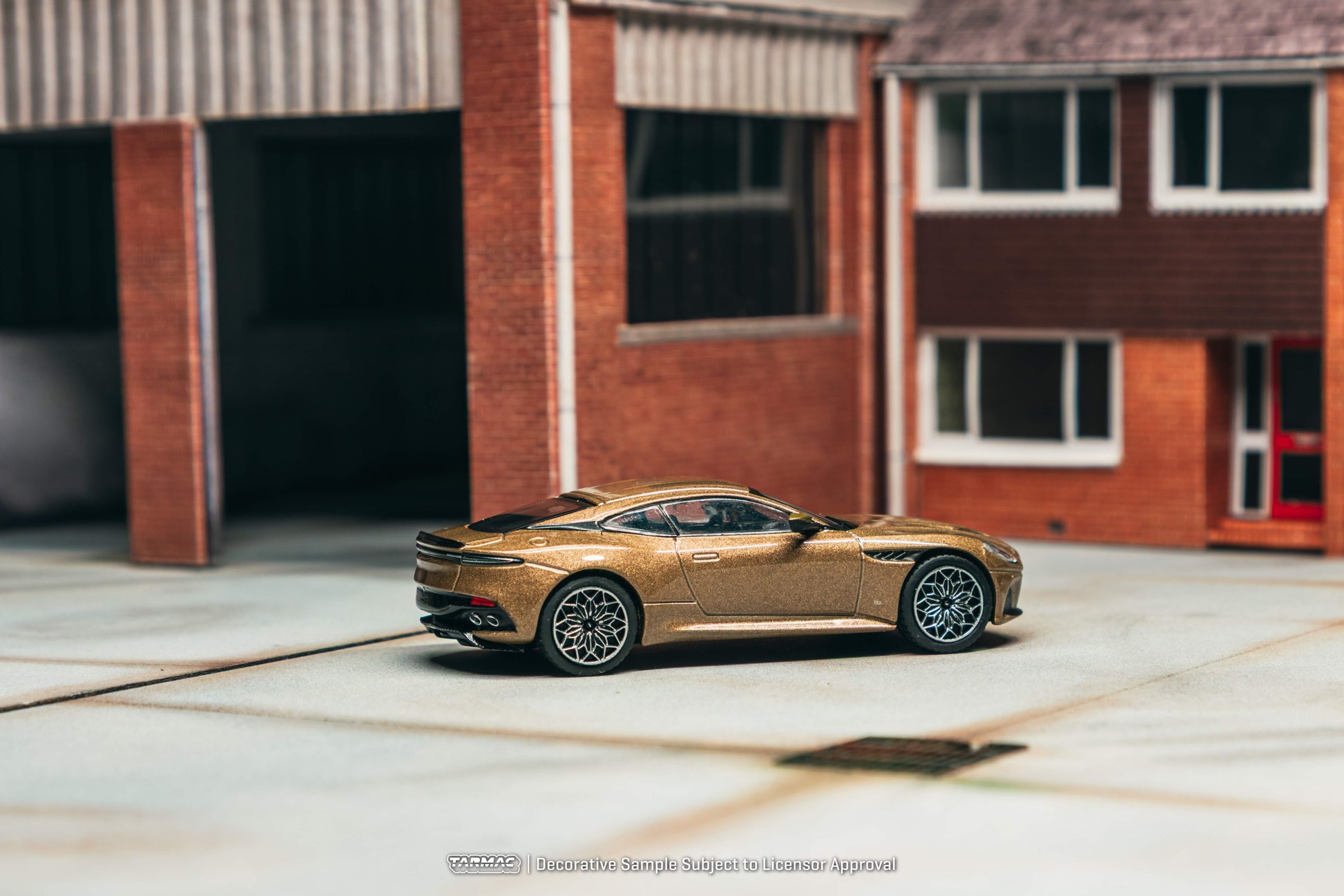 Gold sports car parked in front of a brick building