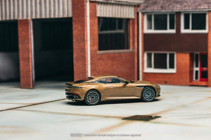 Gold sports car parked in front of a brick building