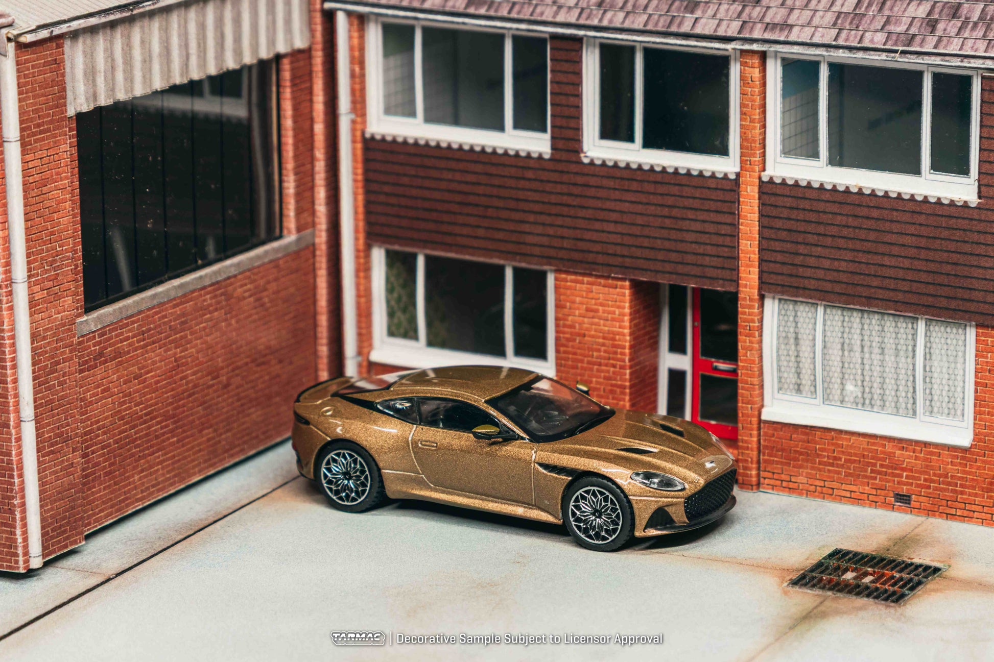 Gold sports car parked in front of a brick building