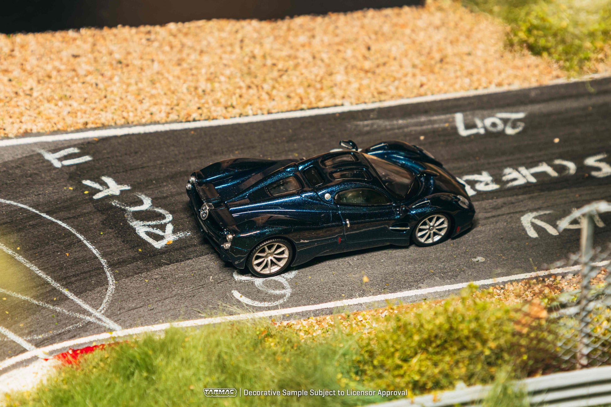 Model car on a miniature race track with gravel and grass