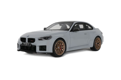 Model car of a BMW M2 with gold rims on a white background