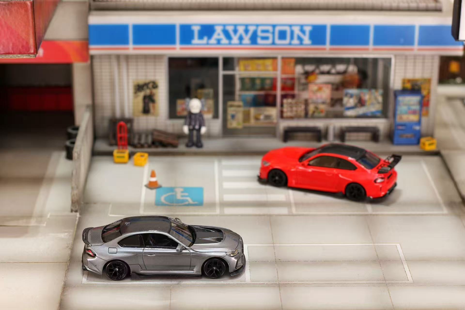 Model cars in front of a Lawson convenience store.