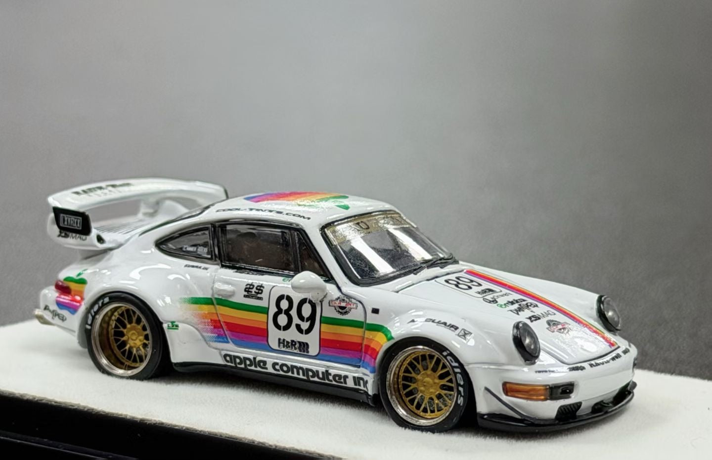 Model car with rainbow stripes and 'apple computer' branding on a gray background