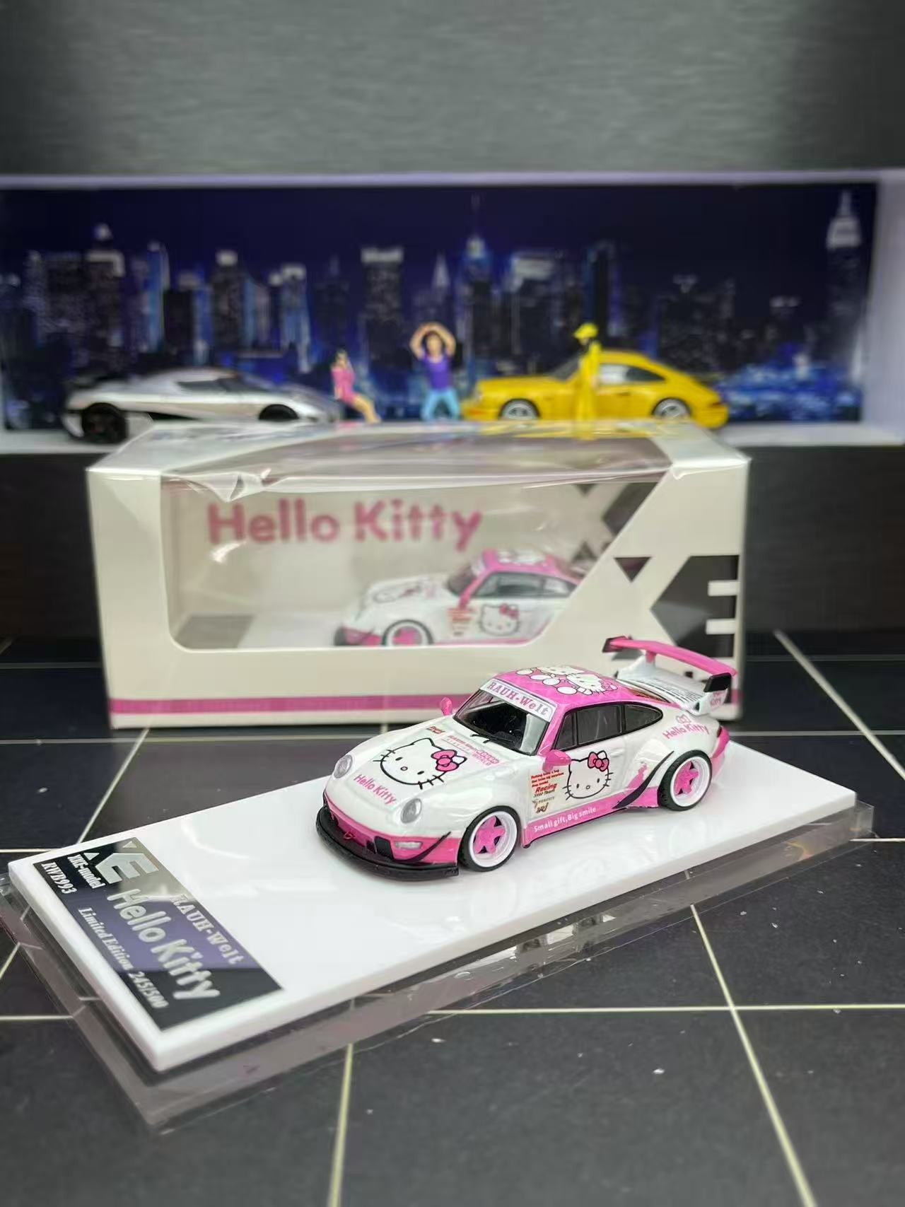 Model car of Hello Kitty design on a display stand with packaging in the background.