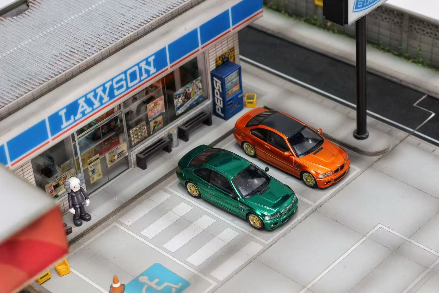 Model of a Lawson convenience store with cars parked outside